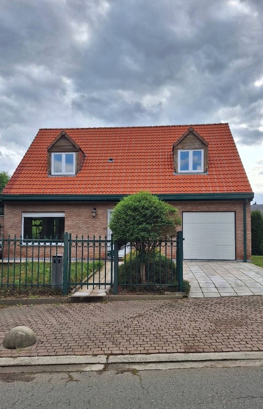 Maison en brique avec toiture en tuiles, vue depuis la rue